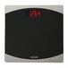 A black Taylor digital bathroom scale with red numbers.