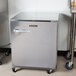 A Traulsen undercounter refrigerator with a right hinged door and wheels.