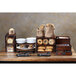 A table with a GET Enterprises walnut rectangular bread box on it filled with a variety of breads and pastries.