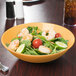 A bowl of salad with shrimp and tomatoes in a GET Tropical Yellow melamine bowl.