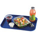 A navy blue Cambro fast food tray with a salad in a plastic container and a container of fruit on it.