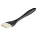 An OXO Good Grips basting brush with a white handle and black silicone bristles.
