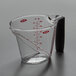An OXO clear plastic measuring cup with a handle and red text.