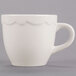 A CAC ivory china espresso cup with a scalloped edge and handle.
