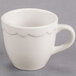 A CAC ivory espresso cup with a scalloped edge and white handle.