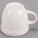 A CAC ivory espresso cup with a scalloped edge and a white handle.