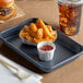 A Baker's Mark aluminum tray with fries and a drink on a table.