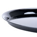 A close-up of a WNA Comet black round catering tray.