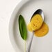 A spoon with Regal Ground Yellow Mustard on a plate.