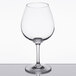 A Carlisle clear plastic wine glass on a reflective surface.