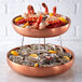 Two American Metalcraft copper seafood trays with seafood and shrimp on a table.
