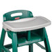 A green high chair with a grey tray.