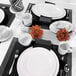 A table set with white Elite Global Solutions round plates and silverware.