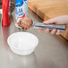 A person using a Zeroll aluminum ice cream scoop to scoop ice cream.