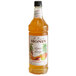 A Monin bottle of orange liquid with a label reading "Premium Honey Mango" syrup.