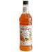 A bottle of Monin orange tangerine syrup with a label.