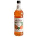 A bottle of Monin Premium Rock Melon Cantaloupe flavoring syrup with a label.