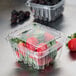 A Pactiv plastic container with strawberries and blackberries in it.