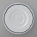 A white Tuxton saucer with a scalloped edge and blue trim.