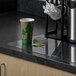 A coffee cup sits on an ES Robbins clear vinyl countertop mat on a counter.