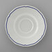 A white saucer with a scalloped edge and blue trim.