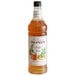 A bottle of Monin Premium Ginger Beer flavoring syrup with a white label.