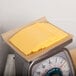 A scale with a stack of Schreiber pre-sliced yellow American cheese on it.