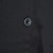 A close up of a black button with a star on a black Chef Revival chef coat.