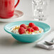 A Tuxton Concentrix island blue china bowl filled with strawberries, raspberries, and nuts on a table.