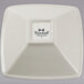 A white square Tuxton china bowl with a logo on it.
