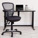A Flash Furniture dark gray mesh office chair next to a desk.