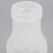A Tablecraft clear plastic syrup dispenser bottle with an almond cap.