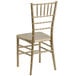 A gold Flash Furniture Hercules Premium Chiavari chair with a white seat and back.