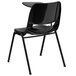 A black plastic Flash Furniture shell chair with a right handed desk attachment.