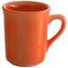 A close-up of a Tuxton papaya orange coffee mug with a handle.