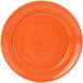 A Tuxton Concentrix papaya china plate with a spiral pattern in orange.