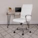 A Flash Furniture white leather swivel office chair with chrome legs next to a desk.