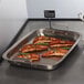 A rectangular stainless steel pan with salmon on it.