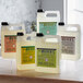 A group of white plastic bottles of Mrs. Meyer's geranium scented hand soap with labels.