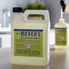 A white Mrs. Meyer's Clean Day jug with a green label on it next to a bottle of soap.