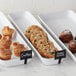 A white American Metalcraft rectangular market tray on a counter with pastries and cookies.