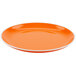 A tangerine orange melamine dinner plate with a white rim.