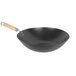 A black wok with a wooden handle.