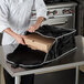 A chef putting a pizza in a Vollrath insulated pizza delivery bag.