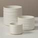 Three American Metalcraft white porcelain sauce cups with ribbed sides.