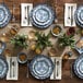 A table set with a stack of American Metalcraft blue and white floral melamine plates and clear glasses of liquid.