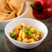 A Carlisle Ridge melamine bouillon bowl filled with chips and a bowl of salsa.