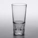 A Libbey customizable stackable beverage glass filled halfway with a clear beverage on a white background.