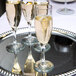 A tray with three Libbey Embassy flute glasses filled with champagne.