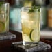 A close-up of an Anchor Hocking Regency Highball glass of lemonade with ice, lime, and mint.